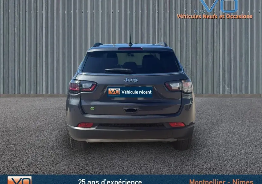 Vue arrière d'un Jeep Compass gris 2023 avec barres de toit et feux arrière LED visibles.
