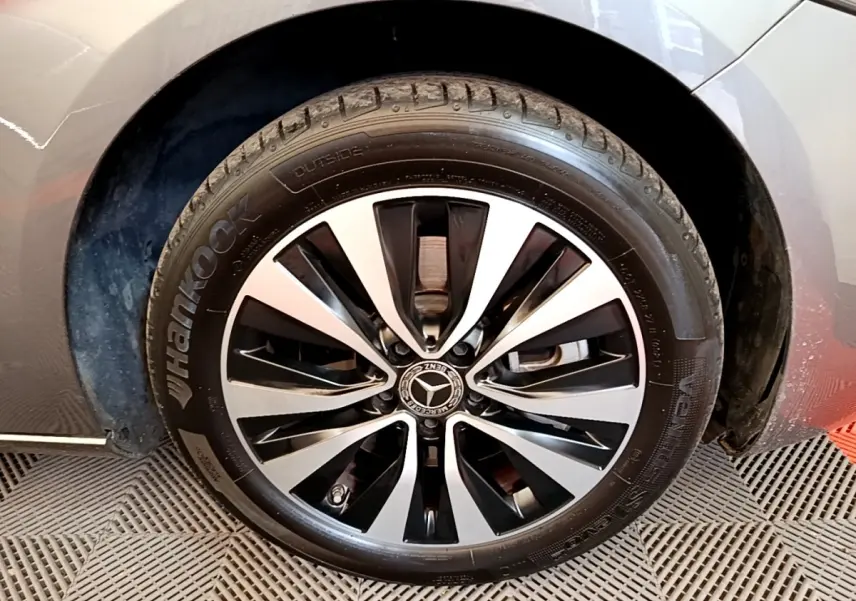 Gros plan sur la roue avant droite grise d'une Mercedes Classe A 250 e Business Line avec jante alliage bicolore.