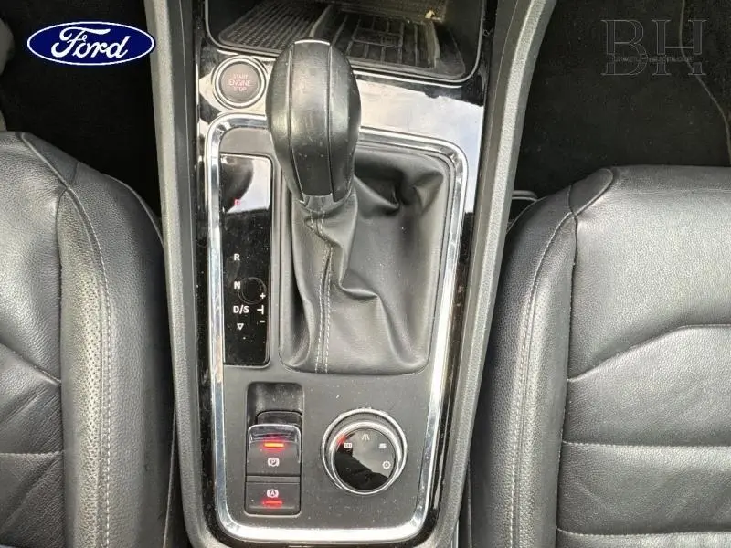 Vue rapprochée de la console centrale avec levier de boîte automatique et sièges cuir noir d'un SEAT Ateca blanc.