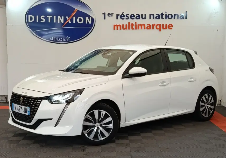 Peugeot 208 blanc vue 3/4 avant droit dans un showroom avec phares LED allumés et jantes stylisées.