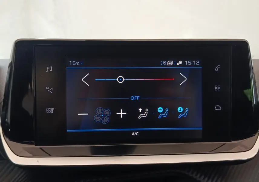 Écran tactile de climatisation du tableau de bord de la Peugeot 208 blanche, affichage digital clair.
