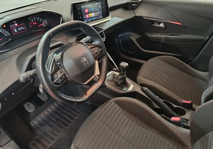 Intérieur noir de la Peugeot 208 PureTech 100 S&S Active Business, vue côté conducteur avec volant cuir et écran tactile central.