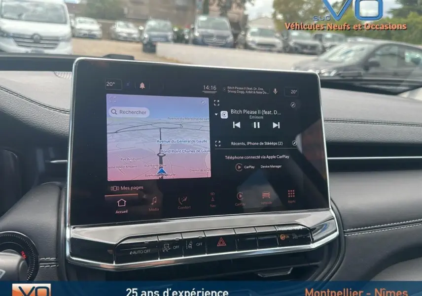 Écran tactile central du Jeep Compass bleu 2023 affichant navigation et musique, vue intérieure du tableau de bord.