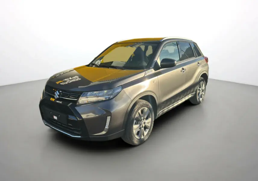 Suzuki Vitara Hybrid 110 Privilège Allgrip gris Titan en 3/4 avant droit avec jantes alu et feux LED allumés.