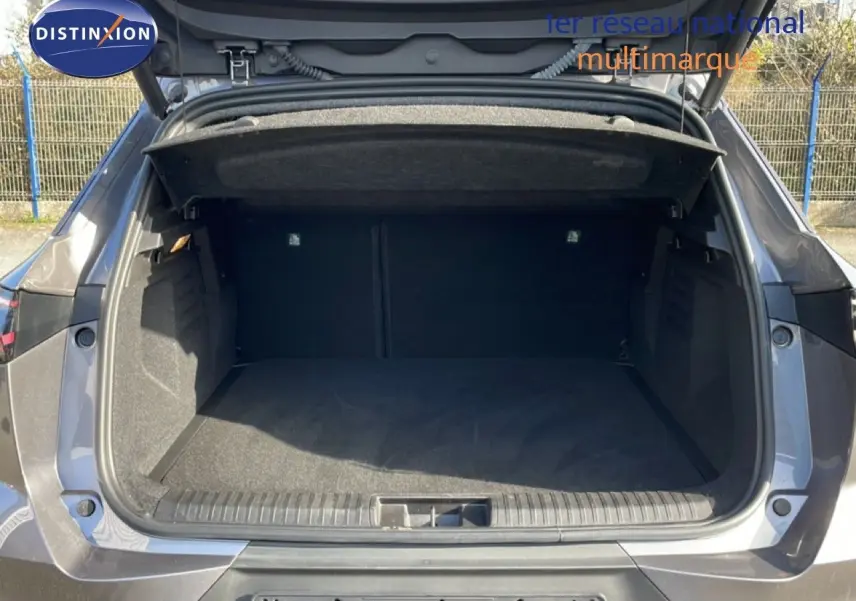 Coffre ouvert vu de l'arrière d'une Renault SYMBIOZ gris cassiopée métal, montrant l'espace de chargement vide.