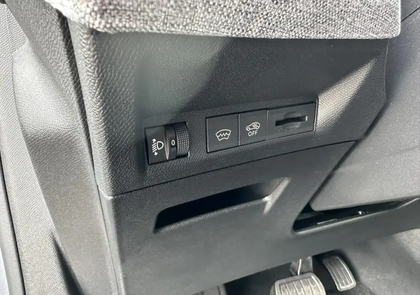 Détail des commandes sous le tableau de bord côté conducteur du Peugeot 3008 gris Artense 2024.