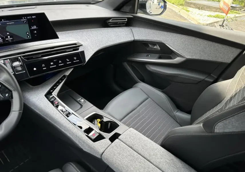 Intérieur avant droit du Peugeot 3008 2024 gris Artense, avec tableau de bord tissu gris et écran tactile panoramique.