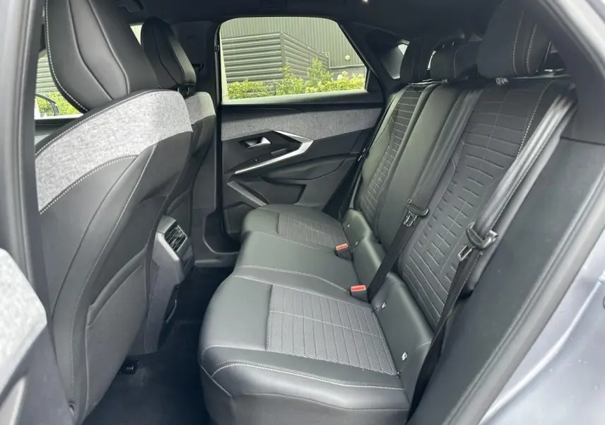 Vue intérieure côté droit des sièges arrière en tissu et cuir noir du Peugeot 3008 gris Artense 2024, avec ceintures et appuie-têtes.