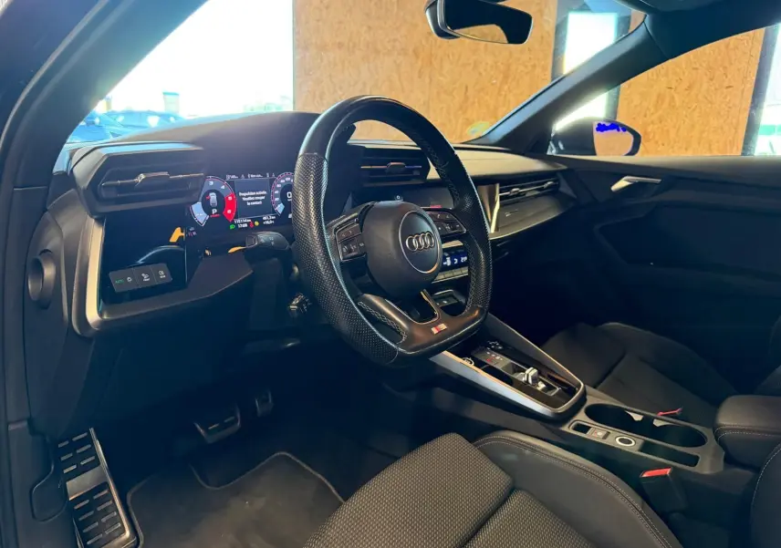 Vue intérieure côté conducteur de l'Audi A3 2.0 TDI 150 S-TRONIC S-LINE 2022 avec volant sport et tableau de bord numérique.