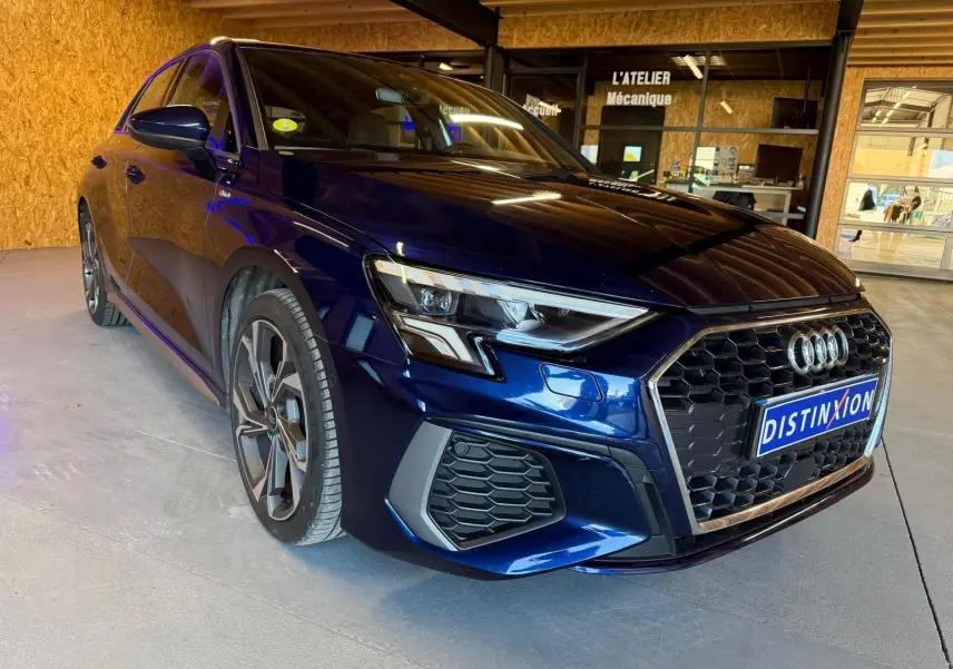 Audi A3 2.0 TDI S-Line bleu vue 3/4 avant droit, avec calandre noire et jantes alliage distinctives.