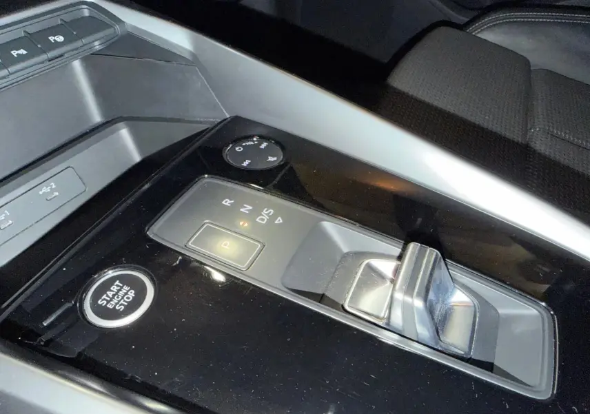 Gros plan sur la console centrale de l'Audi A3 2.0 TDI 150 S-TRONIC S-LINE, avec levier de boîte auto et bouton start/stop.