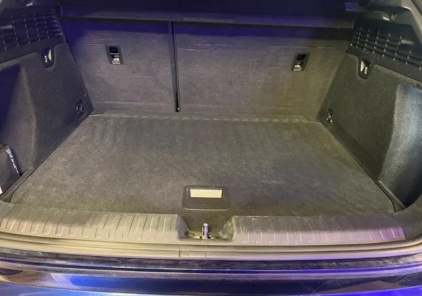 Coffre ouvert vu de face d’une Audi A3 bleu 2022, montrant un espace de chargement propre et spacieux.