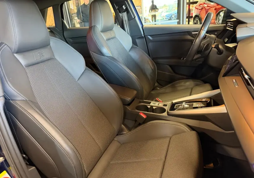 Vue intérieure côté conducteur de l'Audi A3 2.0 TDI S-Line 2022, sièges sport en cuir noir avec surpiqûres contrastées.