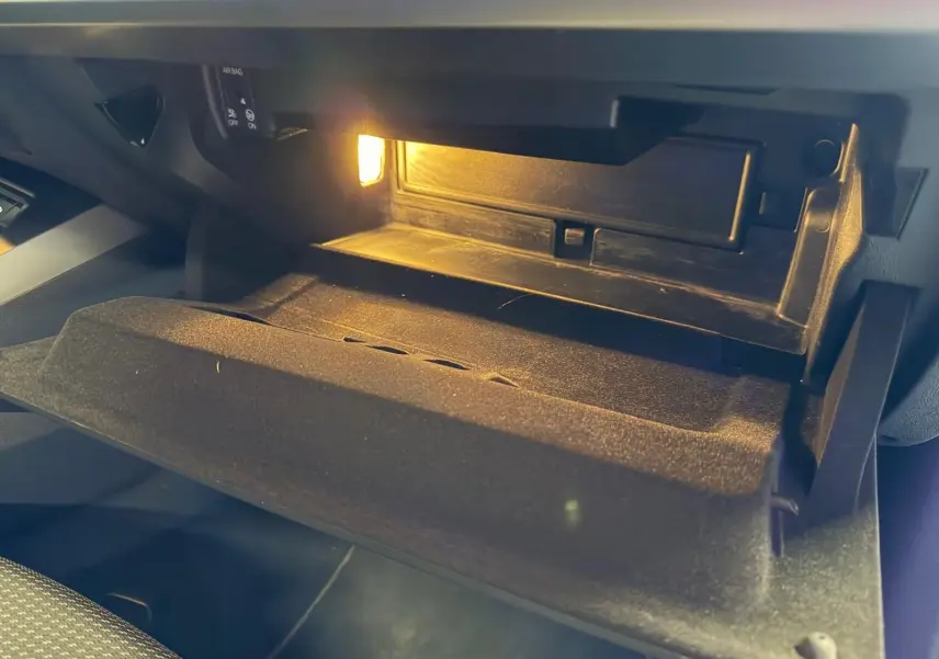 Intérieur de la boîte à gants ouverte avec éclairage, sur l'Audi A3 2.0 TDI S-Line bleu, vue côté passager.