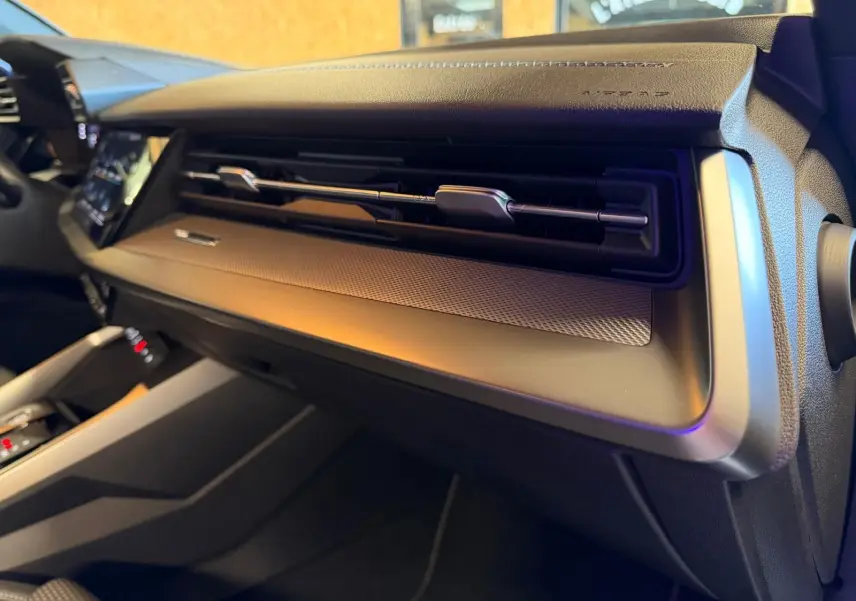 Vue intérieure de l'Audi A3 2.0 TDI 150 S-TRONIC S-LINE 2022, tableau de bord noir avec aérateurs horizontaux et finition métal.