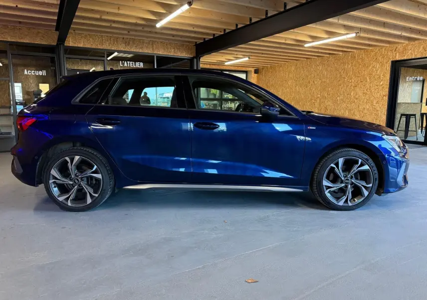 Audi A3 2.0 TDI S-Line bleu vue de profil côté gauche, avec jantes alliage et intérieur visible à travers les vitres.