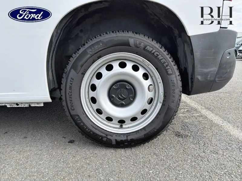 Gros plan sur la roue avant droite du Citroën Berlingo Fourgon blanc Banquise avec jante acier et logo Citroën au centre.