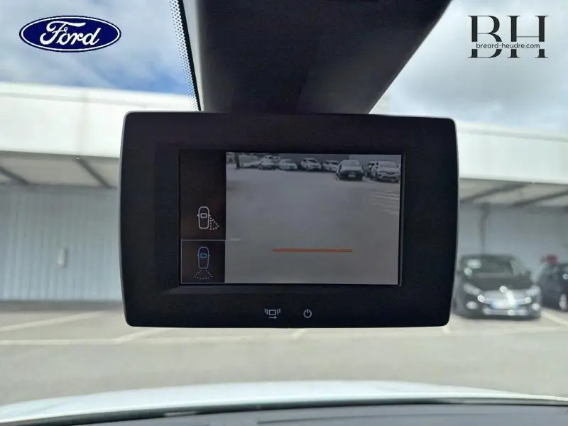 Écran de caméra de recul affichant une vue arrière du parking, intérieur d’un Citroën Berlingo Fourgon blanc Banquise.