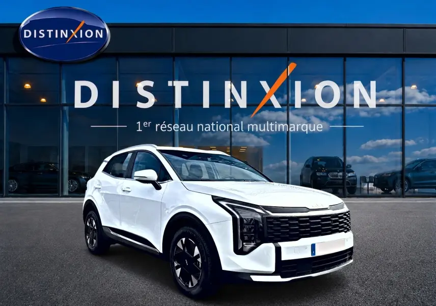 KIA Sportage 1.6 hybride blanc en vue 3/4 avant droit, avec calandre noire distinctive et jantes alu noires.