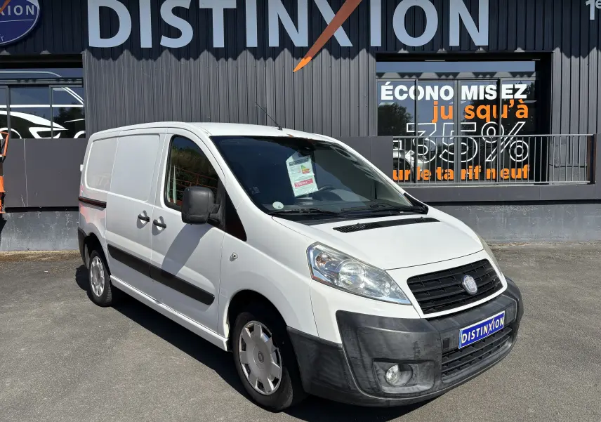 Fourgon FIAT Scudo blanc en 3/4 avant droit, avec pare-chocs noir et logo Distinxion visible sur la plaque avant.