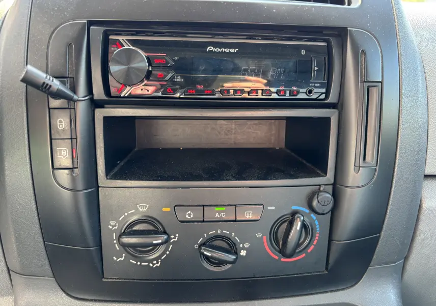 Vue rapprochée de la console centrale noire du Fiat Scudo Fourgon blanc, avec radio Pioneer et commandes de climatisation.