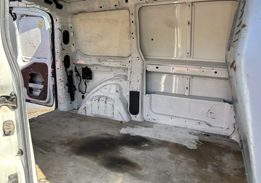 Intérieur arrière du fourgon blanc Fiat Scudo II 2010, vue côté gauche avec plancher usé et porte ouverte.