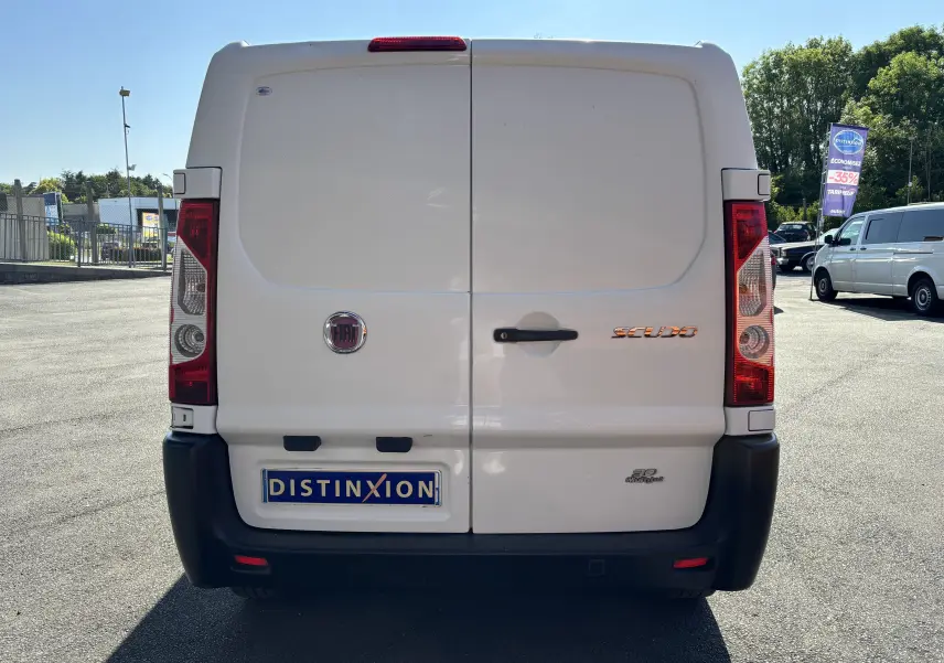 Vue arrière d'un fourgon blanc FIAT Scudo II 1.6 MJTD 90CV de 2010 avec logo et plaque Distinxion.