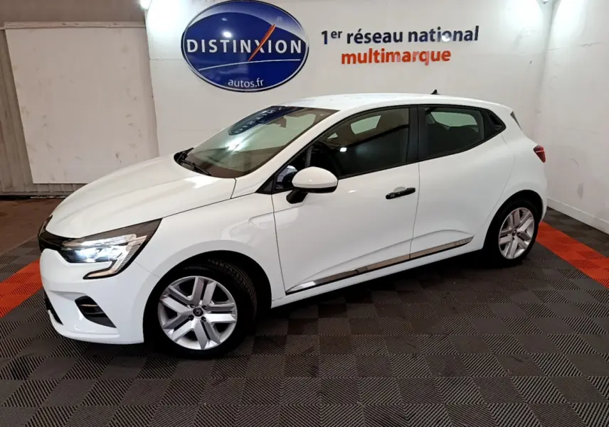 Vue 3/4 avant droite d'une Renault Clio Business blanche 2021 en intérieur avec feux LED allumés.
