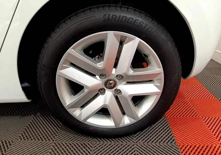 Gros plan sur la roue avant droite blanche d'une Renault Clio Business 2021 avec jante alliage et pneu Bridgestone.