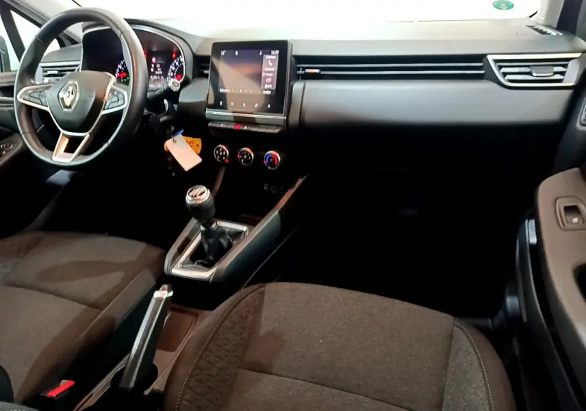 Intérieur de Renault Clio Business 2021 vu côté conducteur, tableau de bord noir avec écran tactile et volant cuir.