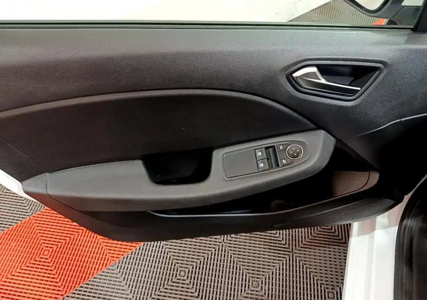 Vue rapprochée de la porte avant gauche noire de la Renault Clio Business blanche, avec commandes électriques des vitres et rétroviseurs.