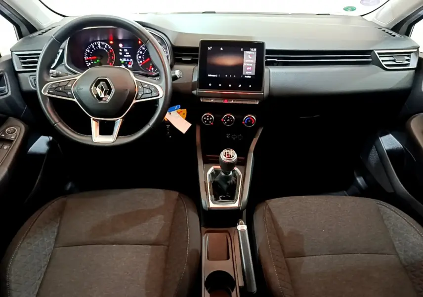 Intérieur de Renault Clio Business blanc 2021, vue frontale sur tableau de bord, volant cuir et écran tactile central.
