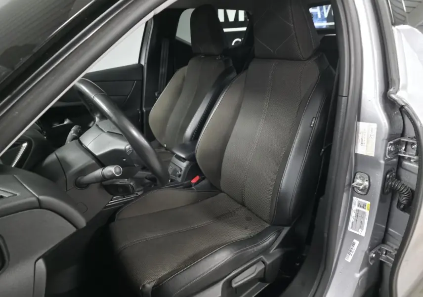 Vue intérieure côté conducteur du DS3 Crossback gris, mettant en valeur le siège avant en tissu Perruzi Bronze et le volant cuir.