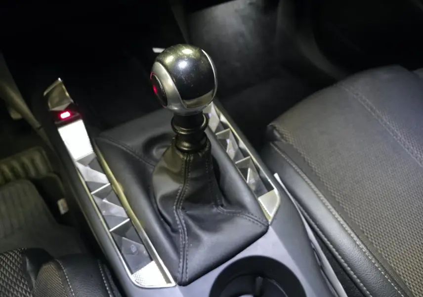 Gros plan sur le levier de vitesses manuel en cuir noir et tissu gris du DS3 Crossback 1.5 BlueHDi Bastille 2022.