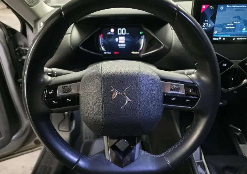 Vue rapprochée du volant cuir noir avec logo DS et tableau de bord numérique du DS3 Crossback 2022.