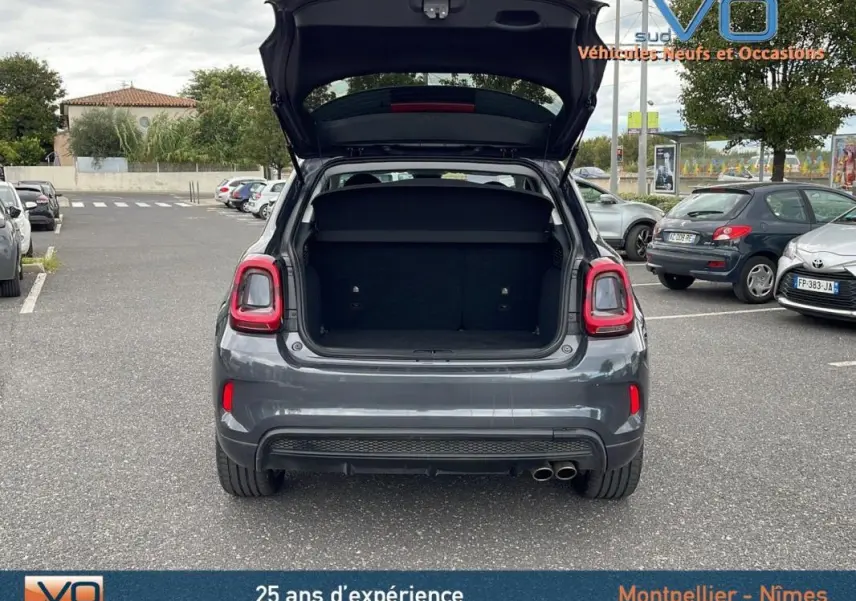 Vue arrière d'une FIAT 500X gris 2023 avec coffre ouvert, feux arrière LED et double sortie d'échappement visible.
