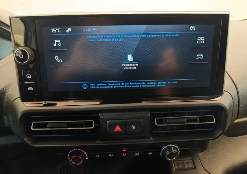 Vue rapprochée de l’écran tactile central et des commandes de climatisation du Peugeot Partner blanc 2026.