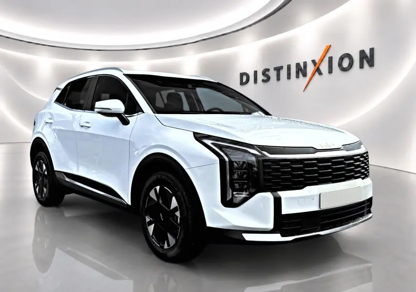 Vue 3/4 avant gauche d'un Kia Sportage blanc 2026 avec calandre noire et jantes alu noires en showroom.