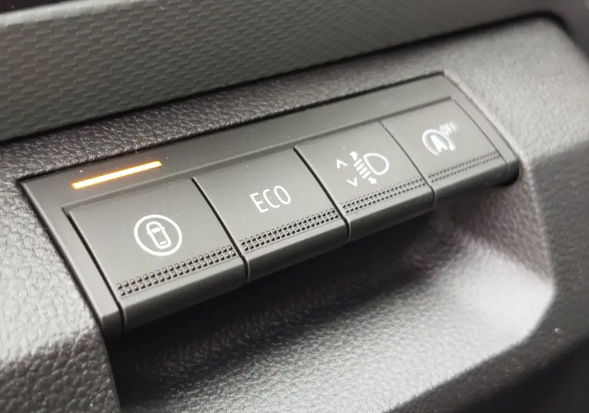 Gros plan sur les boutons de commande du tableau de bord du Dacia Duster gris schiste, version 2025.