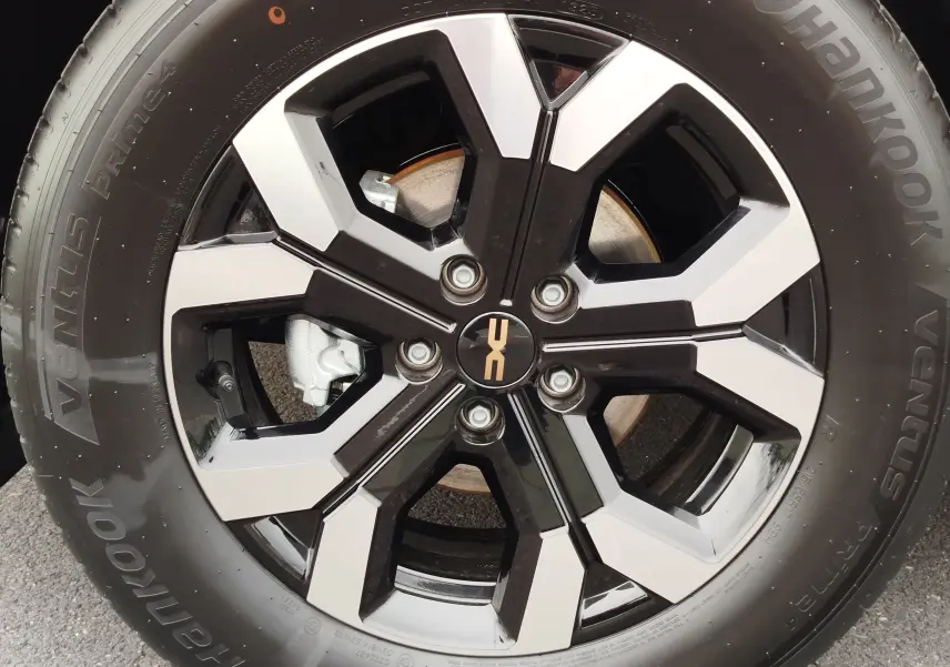 Gros plan sur la jante alliage bicolore noire et argent du Dacia Duster gris schiste 2025 avec pneu Hankook.