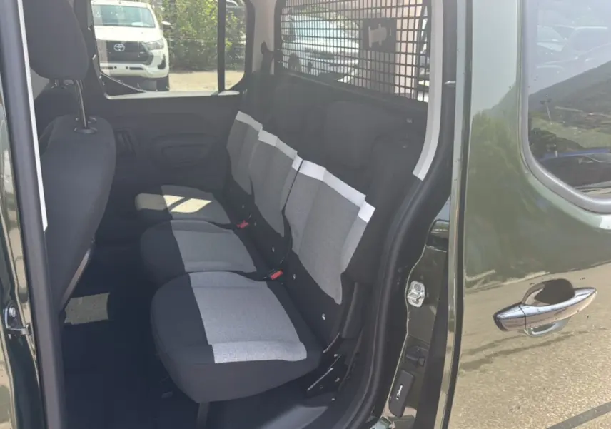 Vue côté droit de l'intérieur arrière d'un Citroën Berlingo Sirkka green avec trois sièges indépendants gris et noirs.