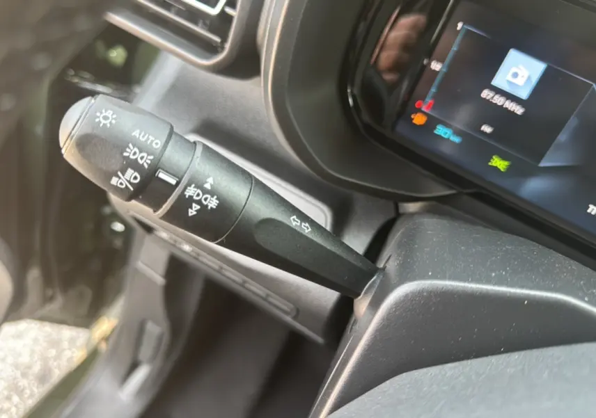 Gros plan sur la commande des feux et clignotants du Citroën Berlingo BlueHDi 130 EAT8 Max, intérieur noir.