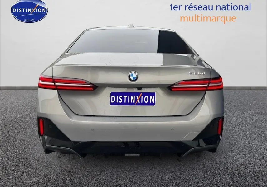Vue arrière d'une BMW Série 5 520da gris avec feux LED et logo distinctif sur fond neutre.
