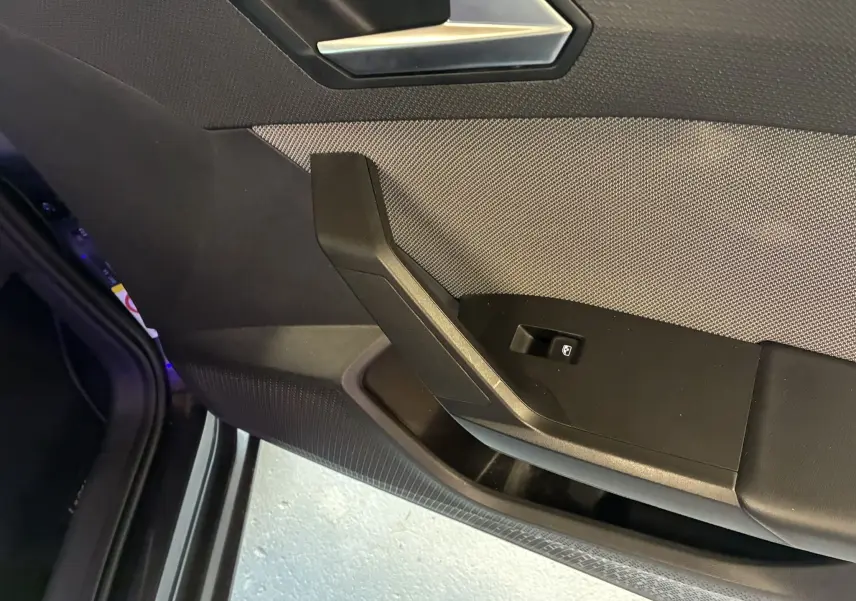 Détail de la porte intérieure côté gauche de la SEAT LEON 2021, finition tissu noir avec commande de vitre électrique.