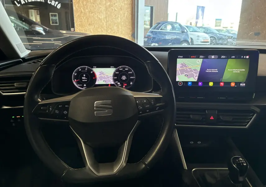 Vue intérieure centrée sur le volant noir et le tableau de bord numérique d'une SEAT LEON 2.0 TDI 115 STYLE 2021.