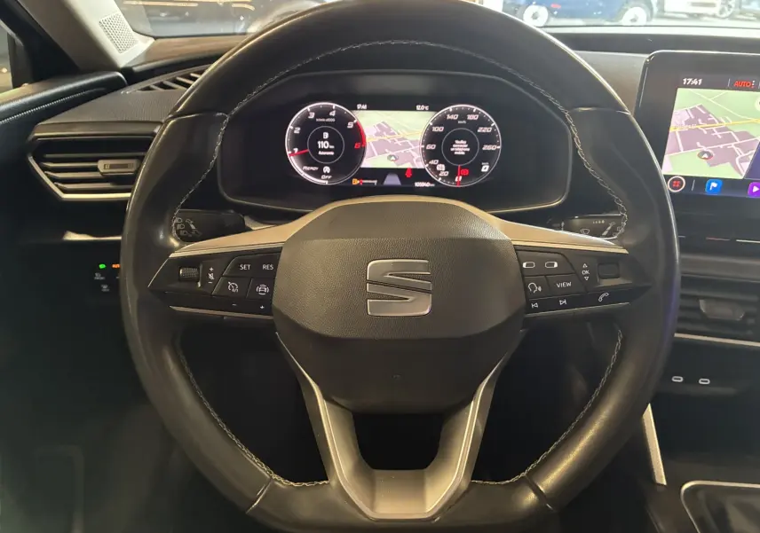 Vue rapprochée du volant noir de la SEAT LEON 2.0 TDI 115 STYLE 2021 avec tableau de bord numérique et écran GPS.