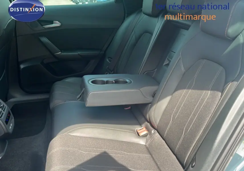 Vue intérieure arrière du CUPRA Formentor 1.5 eTSI 150CH DSG7 2026 avec sièges tissu-cuir noirs et accoudoir central relevé.