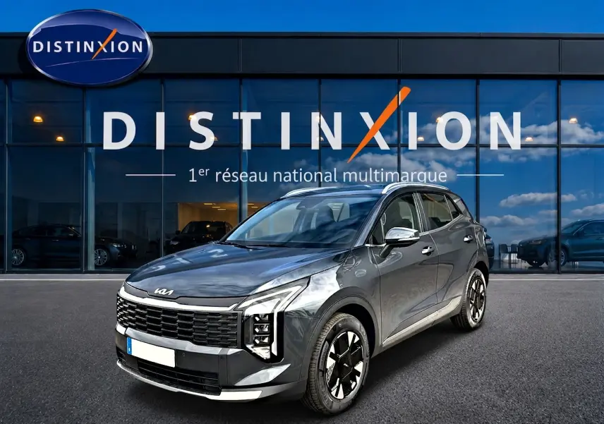KIA Sportage 1.6 hybride gris eclipse en 3/4 avant droit, avec calandre noire distinctive et jantes alu 17 pouces.