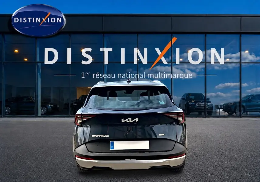 Vue arrière du KIA SPORTAGE 1.6 hybride 239 gris eclipse, avec feux arrière LED et barres de toit visibles.