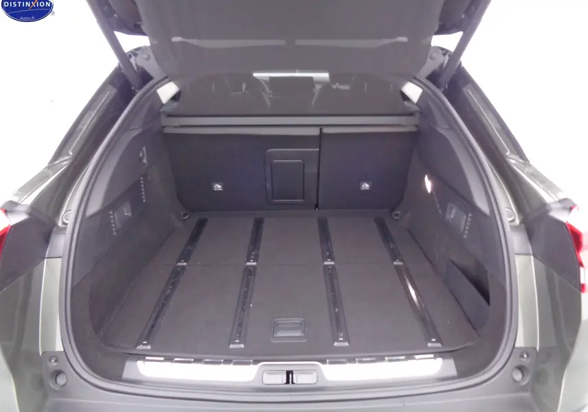 Coffre ouvert en vue arrière d'une Citroën C5 X gris Smart, montrant un grand espace de chargement plat et modulable.